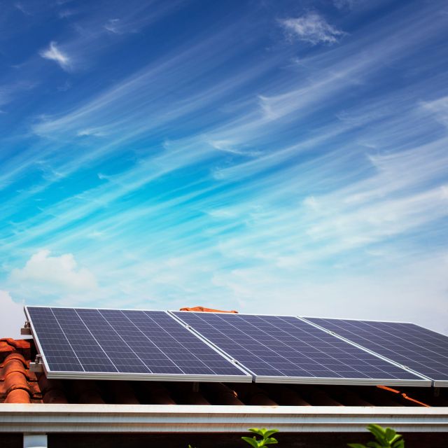 Solar panels on the red roof in a sunny and cloudy day. Photovol